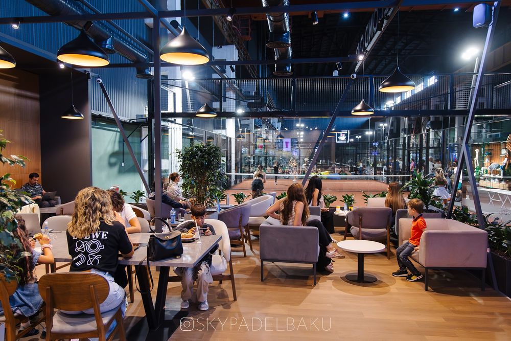 Guests in the café watching a match through the glass